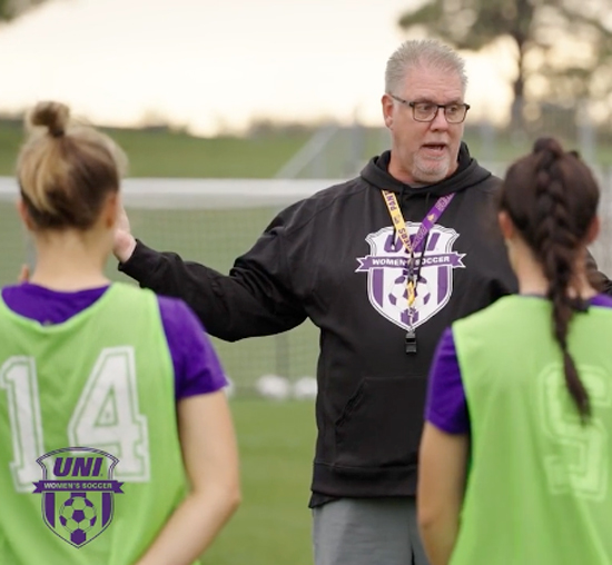 UNI Women's Soccer coach talking to players during a practice