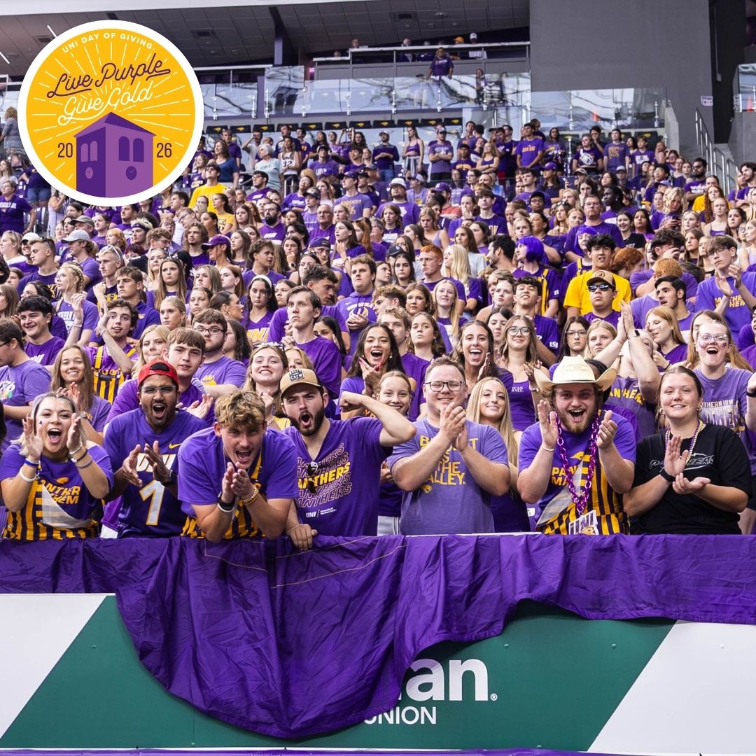 Student section in the UNI Dome with the Live Purple Give Gold logo in the top left corner.