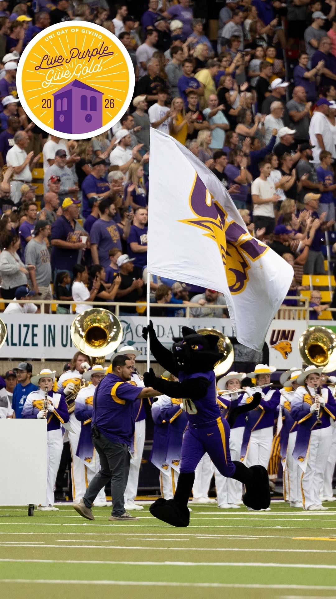 TC carrying a UNI flag with the Live Purple Give Gold logo in the top left corner.