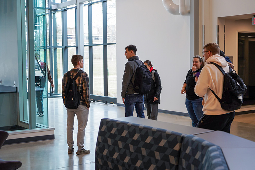 Group of UNI students talking in the hallway of the Applied Engineering Building