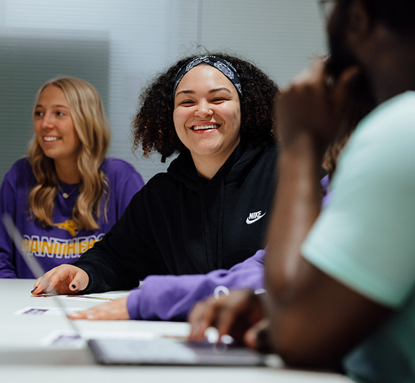 UNI student laughing with group of students while working on a group project